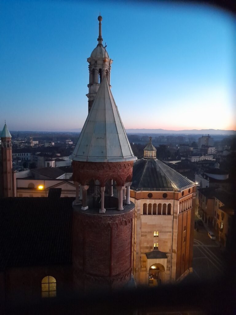 해질녘 이탈리아 성당의 종탑과 돔이 도시 전경 위로 보이는 모습