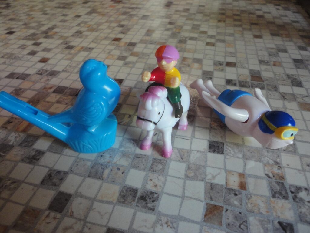 작은 말 인형과 플라스틱 장난감들이 놓여 있는 모습