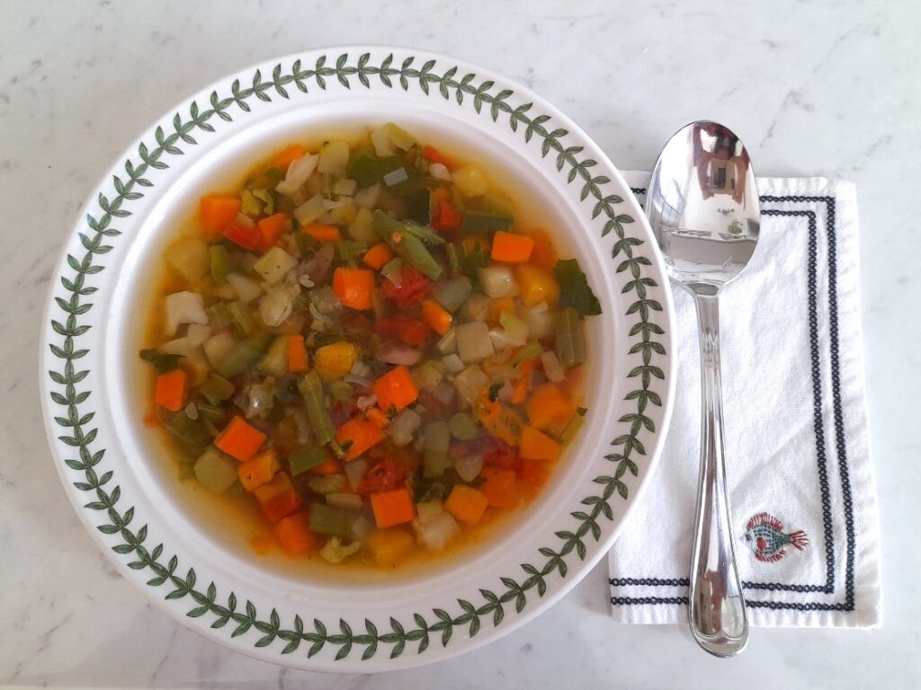 하얀 그릇에 담긴 다진 채소 수프와 냅킨 위 스푼