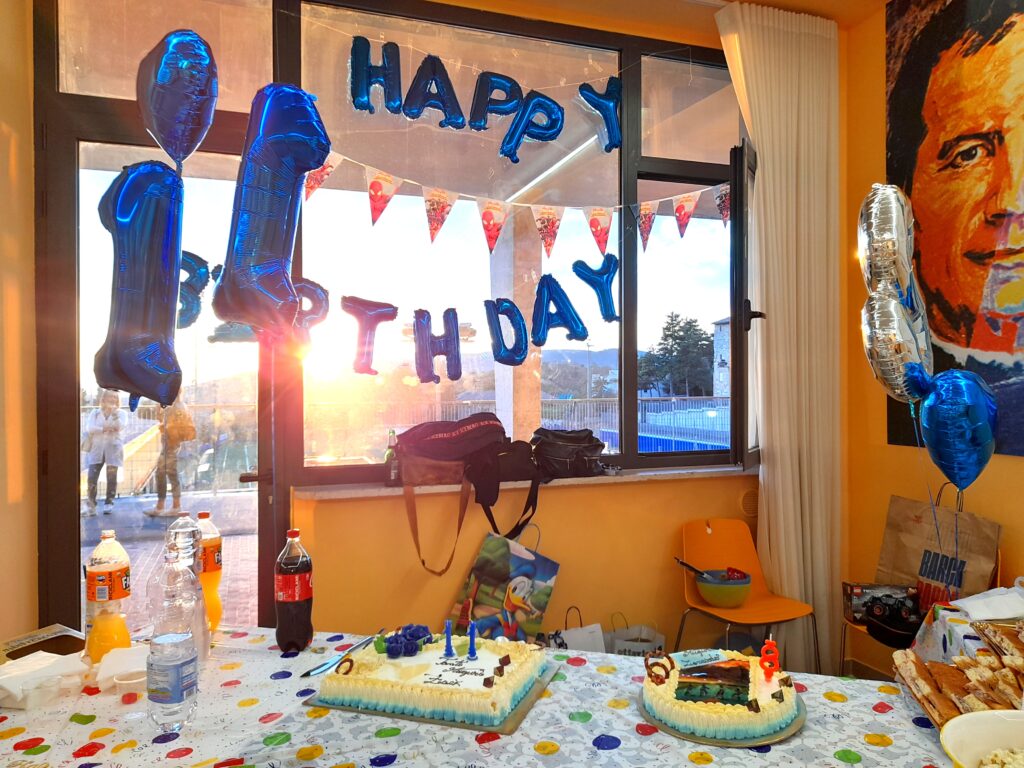 이탈리아 아이 생일파티에서 케이크와 풍선 장식이 준비된 실내 모습