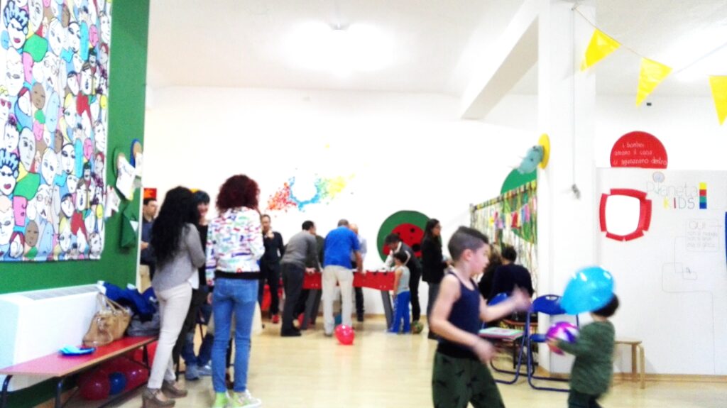 이탈리아 아이 생일파티에서 부모와 아이들이 함께 모여 있는 실내 파티 공간