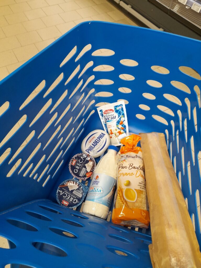 이탈리아 슈퍼마켓 장바구니 안에 우유와 요거트, 리코타, 식빵이 담겨 있다
