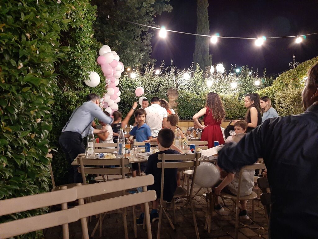 이탈리아 가정 정원에서 열린 아이 생일파티에서 가족들과 아이들이 함께 모여 있는 모습
